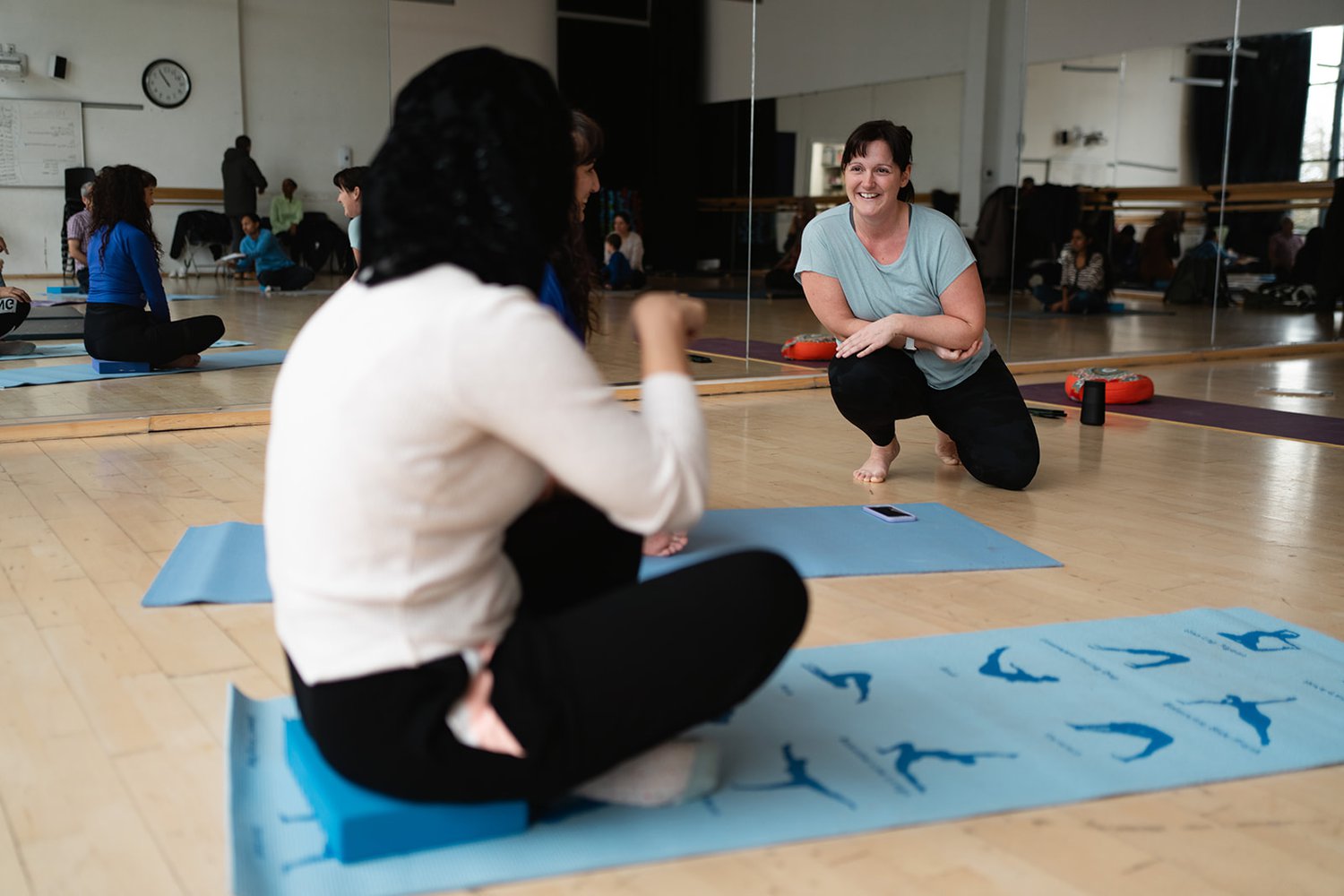 Photo of a female yoga instructor and a female yoga participant