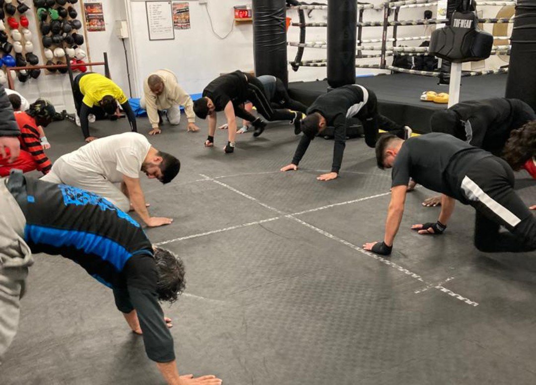 Men in gym  doing press ups in a circle